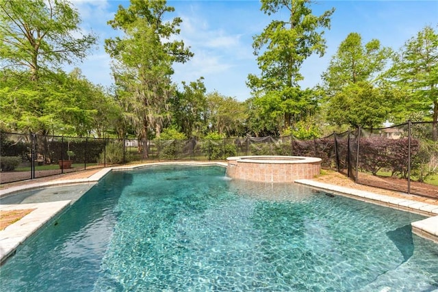 view of pool with a pool with connected hot tub and fence