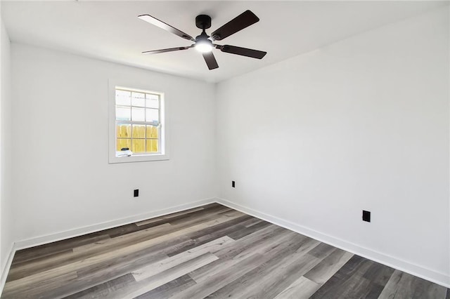 spare room with ceiling fan, baseboards, and dark wood finished floors