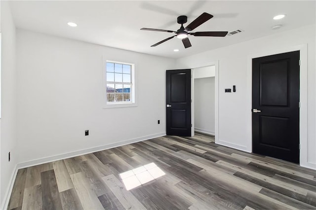 unfurnished bedroom with baseboards, visible vents, wood finished floors, and recessed lighting