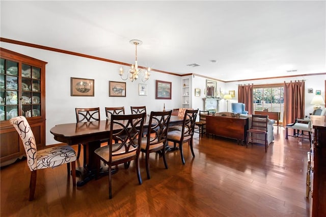 dining space featuring visible vents, a notable chandelier, wood finished floors, and crown molding