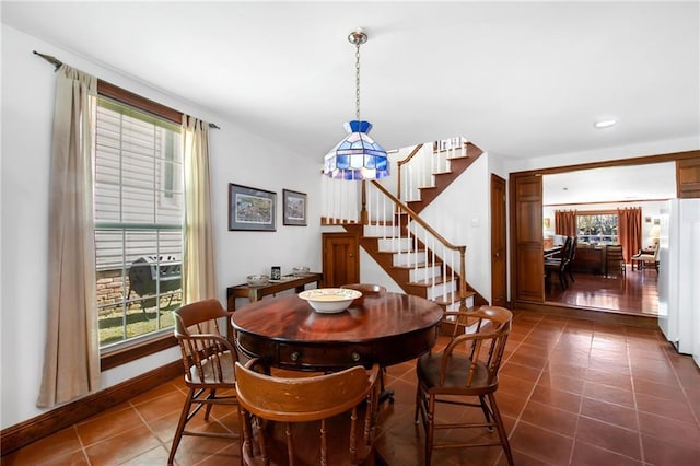 dining space featuring dark tile patterned floors, recessed lighting, stairs, and baseboards