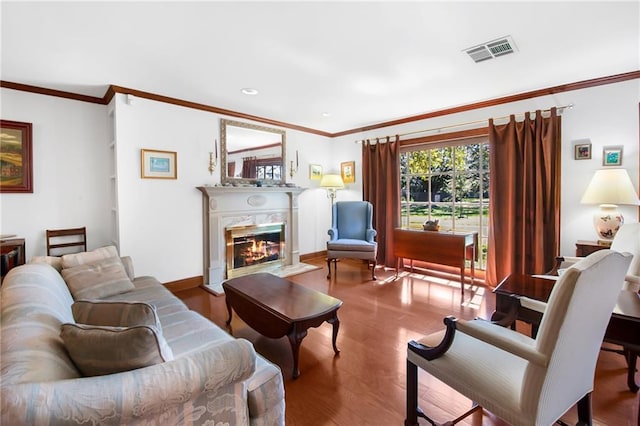 living area with wood finished floors, visible vents, baseboards, a high end fireplace, and crown molding