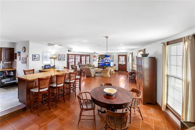 tiled dining room featuring a healthy amount of sunlight and visible vents