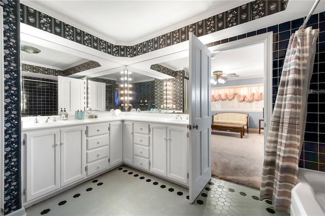 full bath featuring wallpapered walls, double vanity, and a sink