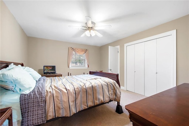 bedroom featuring a closet, light colored carpet, and a ceiling fan