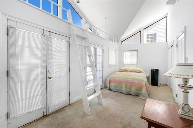 carpeted bedroom featuring high vaulted ceiling