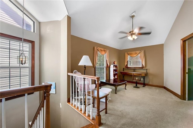 living area with an upstairs landing, lofted ceiling, carpet flooring, baseboards, and ceiling fan