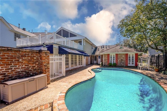 view of swimming pool with french doors, a patio, a fenced in pool, and fence