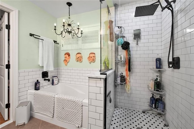 full bathroom with tile patterned floors, walk in shower, a chandelier, a bath, and tile walls