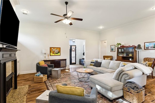 living area featuring ornamental molding, wood finished floors, and a premium fireplace