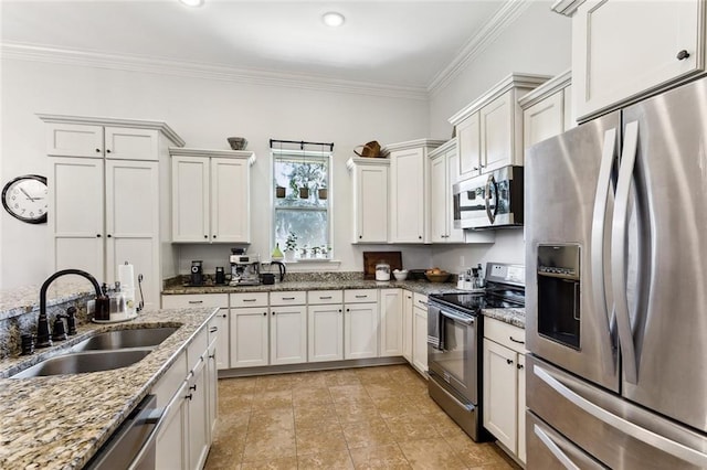 kitchen with light stone countertops, a sink, stainless steel appliances, white cabinetry, and crown molding