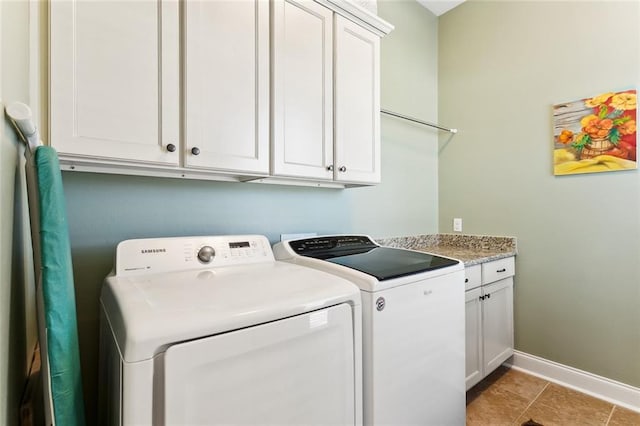 clothes washing area with light tile patterned floors, baseboards, cabinet space, and separate washer and dryer