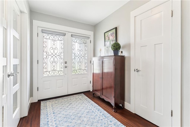 entryway with dark wood-style floors, baseboards, and french doors