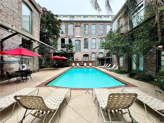 pool with a patio area and fence