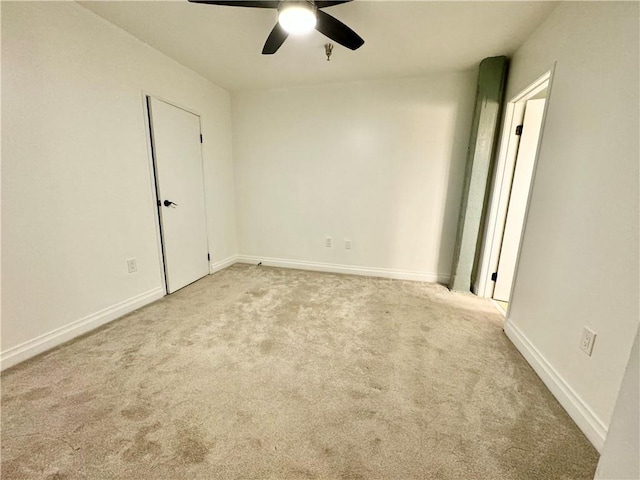 empty room featuring a ceiling fan, carpet, and baseboards