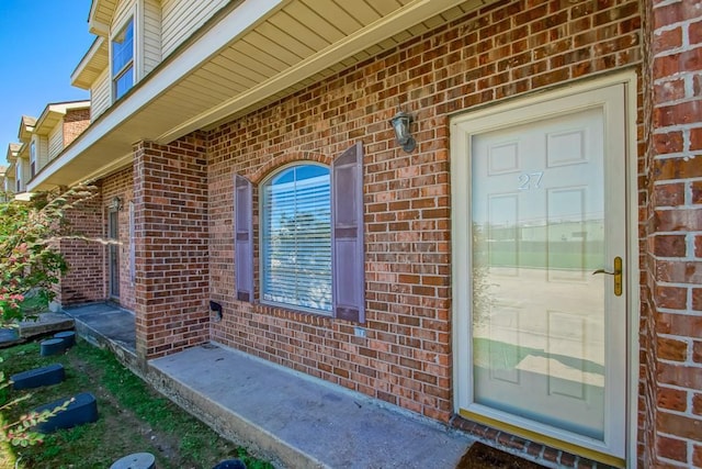 view of exterior entry with brick siding