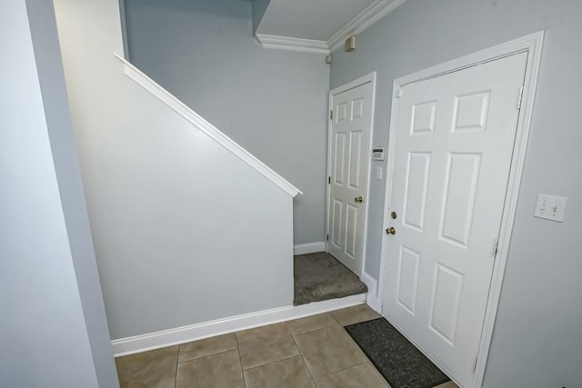 tiled foyer with stairway, crown molding, and baseboards