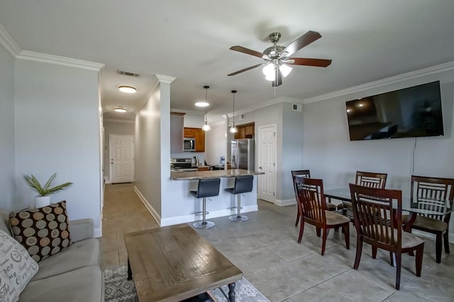 living area with visible vents, crown molding, light tile patterned floors, baseboards, and ceiling fan