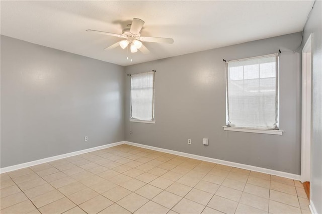 spare room featuring a ceiling fan and baseboards