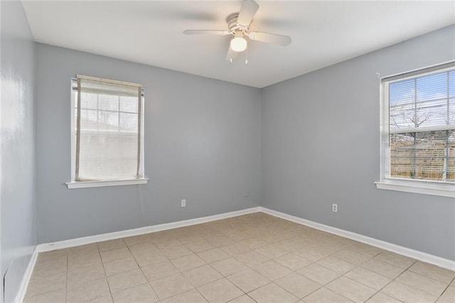 spare room with baseboards, a wealth of natural light, and ceiling fan