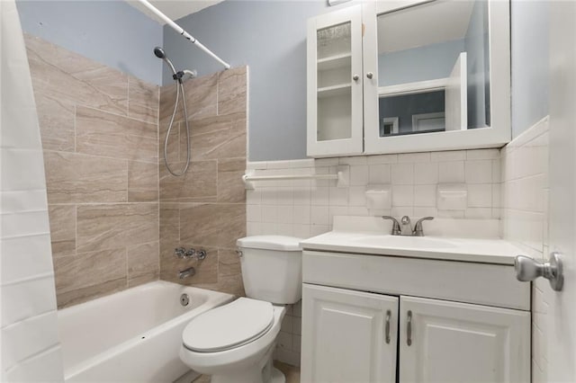 full bathroom featuring toilet, tile walls, bathtub / shower combination, and vanity