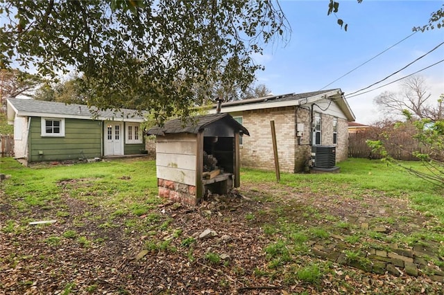 exterior space with an outbuilding, central AC unit, and fence