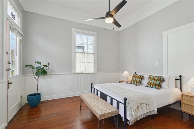 bedroom featuring wainscoting, a ceiling fan, and wood finished floors