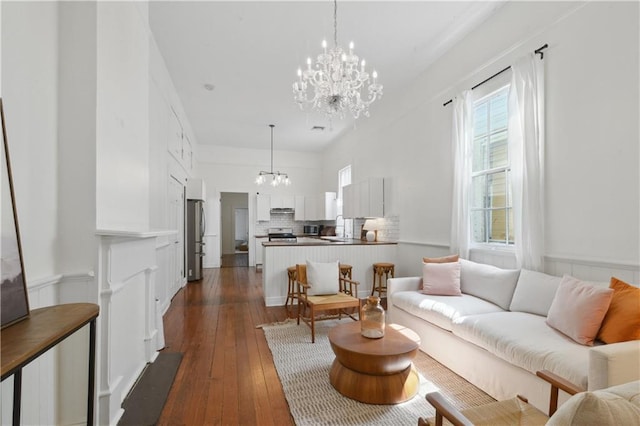 living area with a chandelier and dark wood finished floors