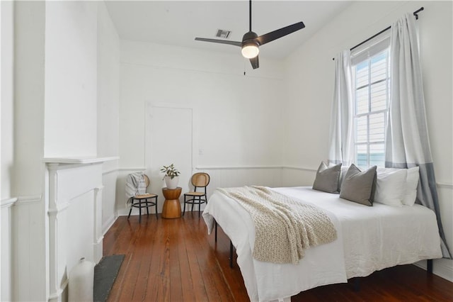 bedroom with ceiling fan, visible vents, and hardwood / wood-style floors