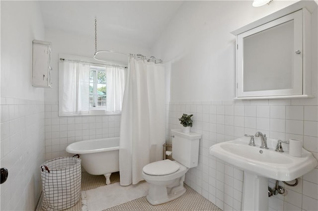 full bathroom featuring tile patterned floors, a soaking tub, toilet, and tile walls