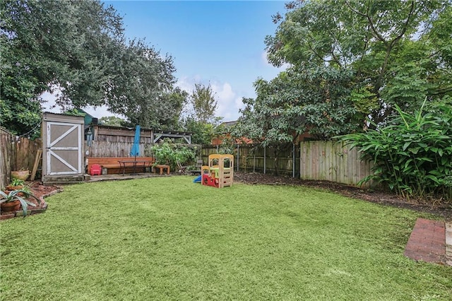 view of yard with a storage shed, an outdoor structure, and a fenced backyard