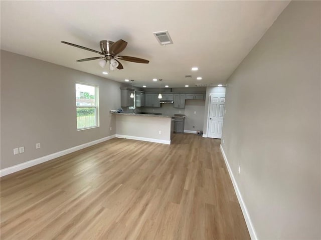 4612 Majestic Oaks Dr, New Orleans, LA 70126 - unfurnished living room featuring visible vents, light wood-type flooring, baseboards, and ceiling fan
