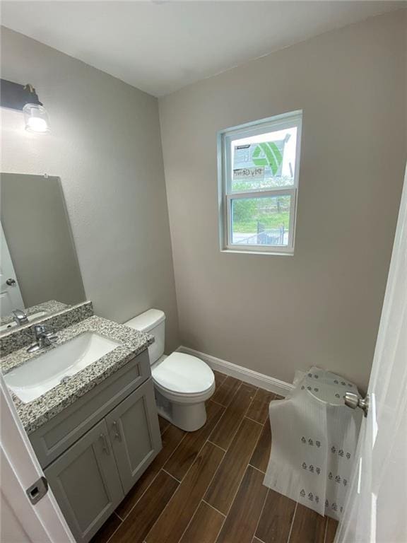 4612 Majestic Oaks Dr, New Orleans, LA 70126 - bathroom with toilet, wood finished floors, vanity, and baseboards