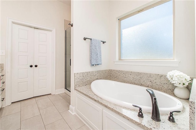 bathroom featuring a bath, tile patterned flooring, and a stall shower