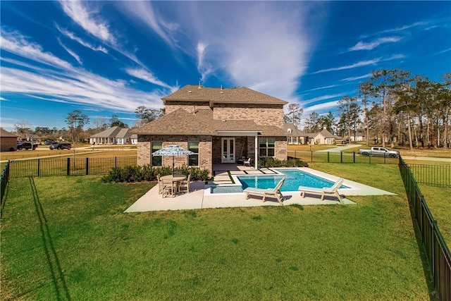 rear view of house with a lawn, a patio, a fenced backyard, a fenced in pool, and brick siding