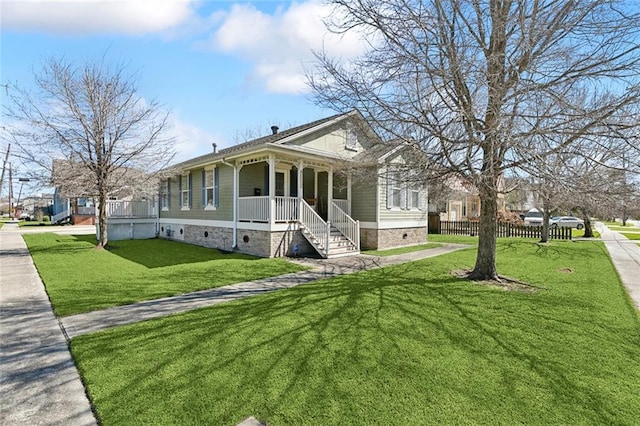 view of front of property featuring a front lawn, fence, and covered porch