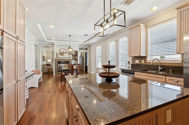 kitchen with visible vents, a tile fireplace, a sink, dishwasher, and crown molding