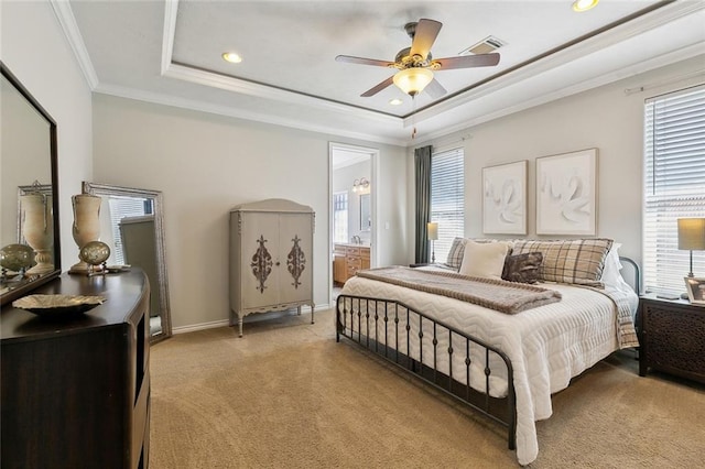 bedroom with visible vents, light carpet, ornamental molding, a tray ceiling, and baseboards