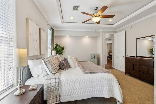 bedroom with visible vents, crown molding, a tray ceiling, light carpet, and recessed lighting