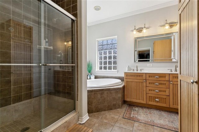 bathroom with tile patterned flooring, ornamental molding, a stall shower, a bath, and a sink