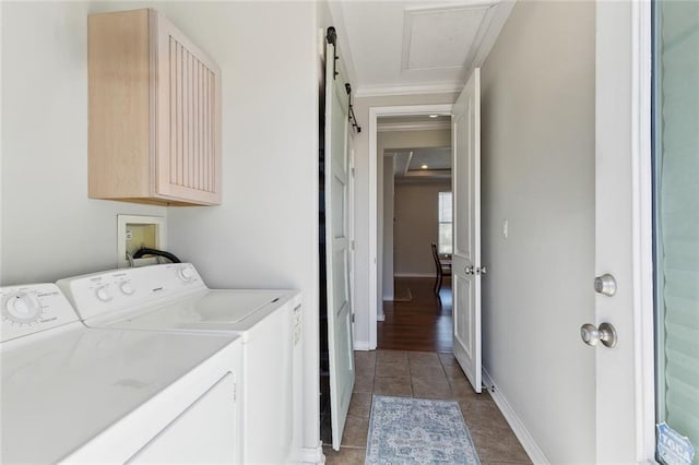 washroom with tile patterned flooring, a barn door, washing machine and dryer, and baseboards