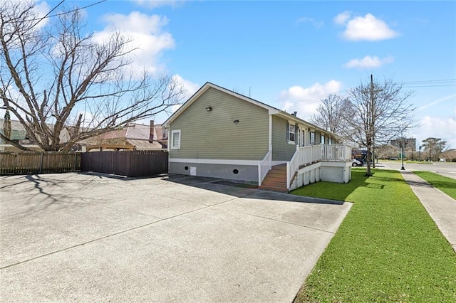 view of side of property featuring stairs, a yard, and fence