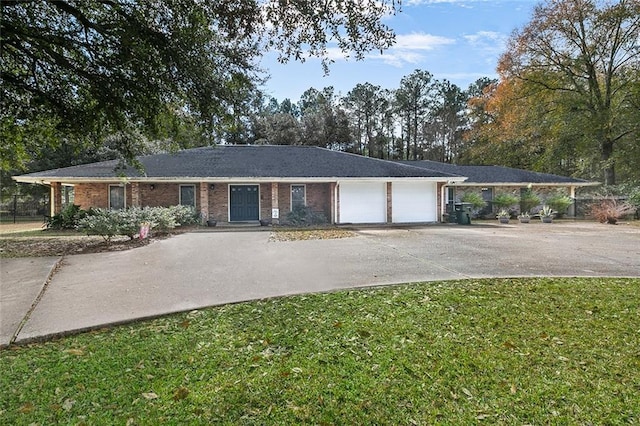 ranch-style home featuring a front lawn, an attached garage, brick siding, and driveway