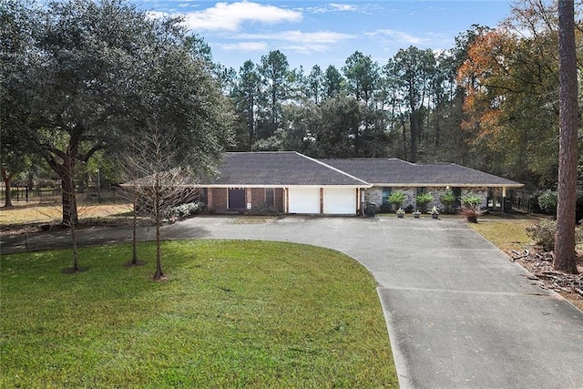 ranch-style house featuring a front yard, brick siding, a garage, and driveway