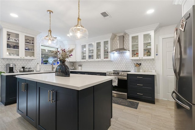 kitchen featuring white cabinets, wall chimney exhaust hood, visible vents, and stainless steel appliances