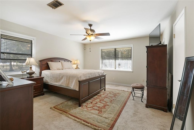 bedroom with light carpet, visible vents, baseboards, and ceiling fan