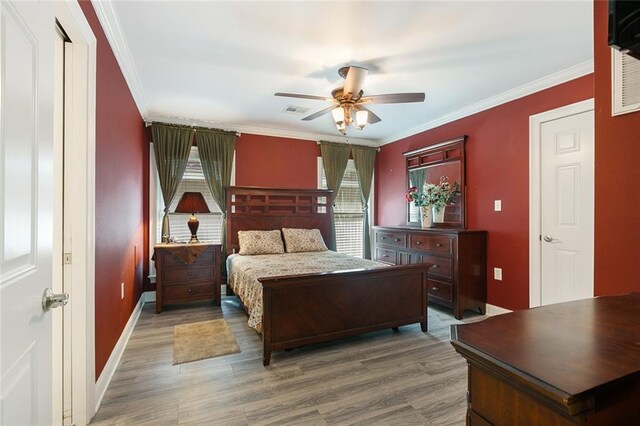 bedroom with visible vents, wood finished floors, and ornamental molding