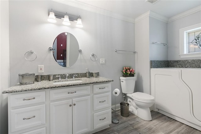 bathroom with vanity, wood finished floors, visible vents, crown molding, and toilet