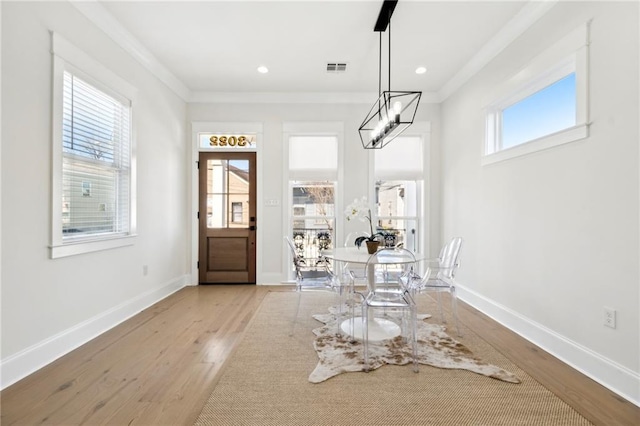 entrance foyer featuring wood finished floors, baseboards, and ornamental molding