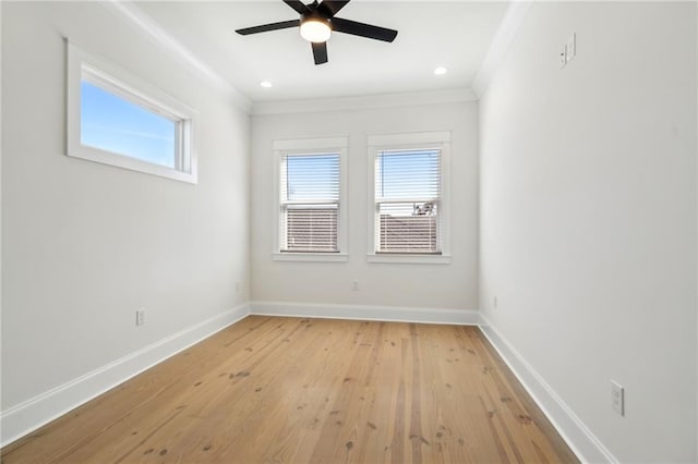 spare room featuring baseboards, plenty of natural light, light wood-style floors, and crown molding